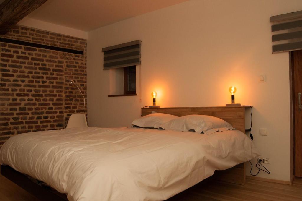 リエージュにあるLaGrange-Chambres d'hôtesのベッドルーム1室(大型ベッド1台、2つの照明付)