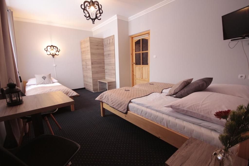 sypialnia z dużym łóżkiem i biurkiem w obiekcie Dom Wypoczynkowy u Czerników w mieście Białka Tatrzanska