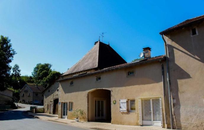 a building with a chimney on top of it at Gîte de la Grande Fontaine in Isches