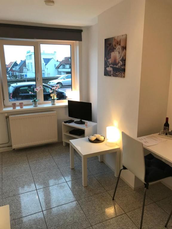 een kamer met een bureau, een computer en een raam bij Apartment de Boer in Zandvoort