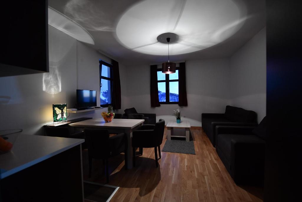 a living room with a table and a couch at Dvori Apartments 8C in Kopaonik