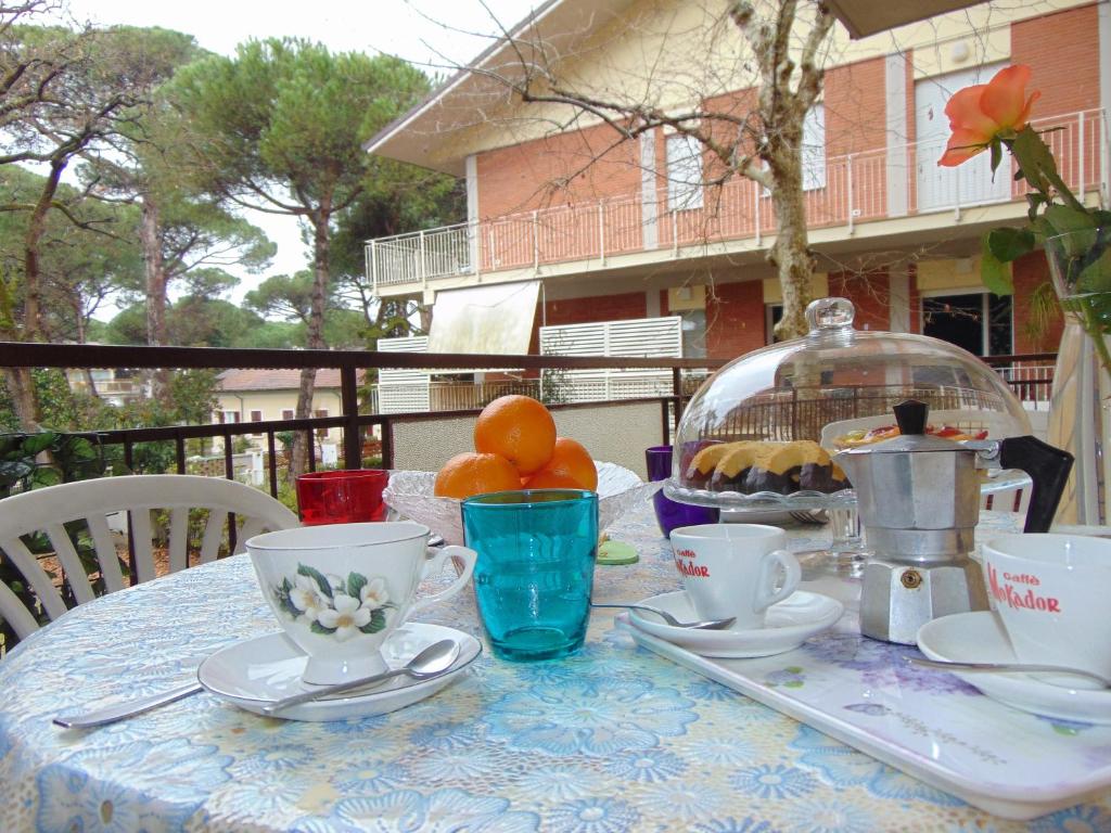 una mesa cubierta con tazas y platillos con fruta. en Mi.Ma's dream en Milano Marittima