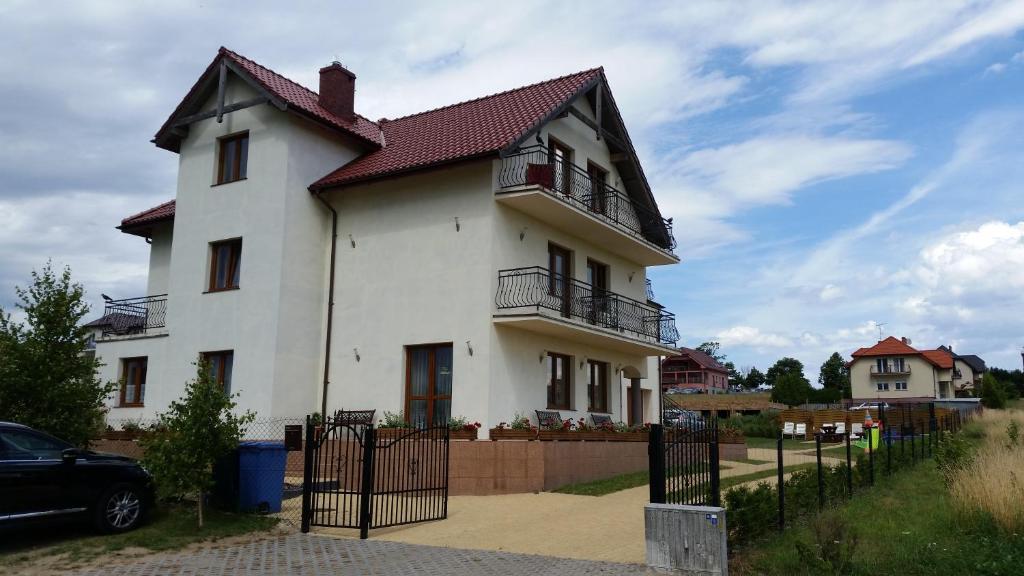 Biały dom z płotem przed nim w obiekcie Willa Admiralska w mieście Jarosławiec