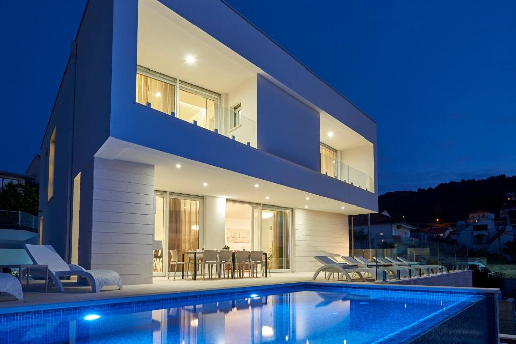 a house with a swimming pool at night at Villa Trogir in Trogir