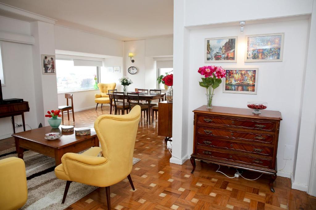 a living room with a yellow chair and a table at Apartamento Vintage 2 in Porto