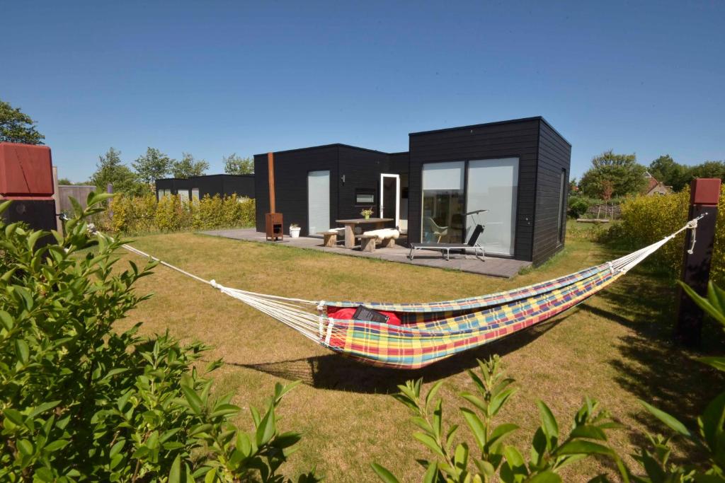 a hammock in front of a black house at Wadzand in Midsland