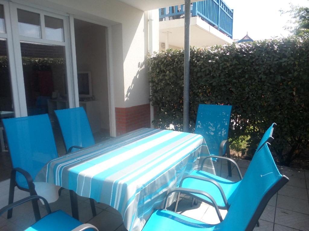 - un ensemble de chaises bleues et une table sur une terrasse dans l'établissement 2 pieces a la teste de buch, à La Teste-de-Buch