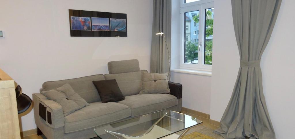 a living room with a couch and a window at Sonnberg Design Apartment in Vienna