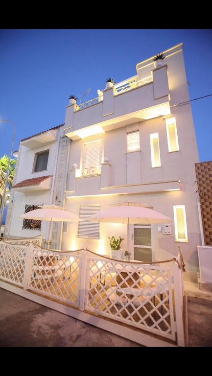 a large white building with a gate and an umbrella at Dimore di Mare in San Pietro Vernotico
