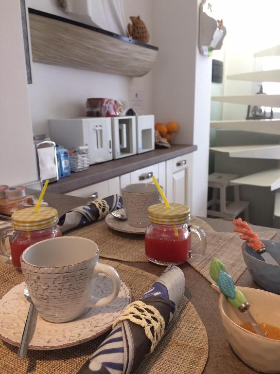 a table with cups of tea and jars of jam at Dimore di Mare in San Pietro Vernotico