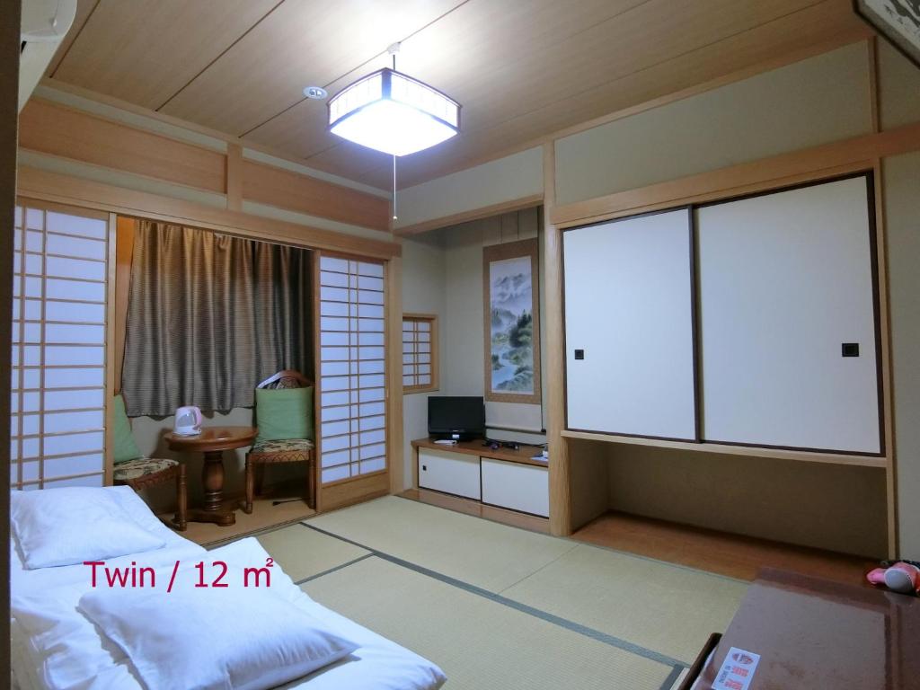 Postel nebo postele na pokoji v ubytování Ryokan Kyoraku