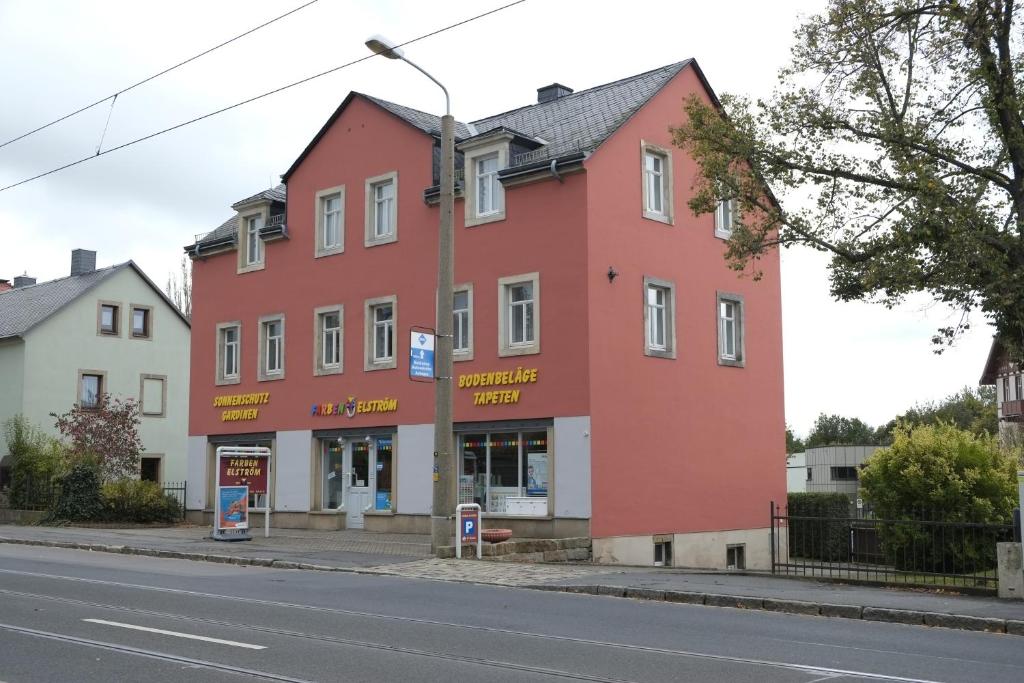 ein rotes Gebäude am Straßenrand in der Unterkunft Gästewohnung Elström in Dresden