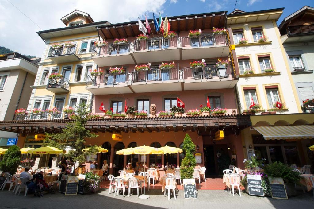 ein Hotel mit Tischen und Stühlen davor in der Unterkunft Hotel Toscana in Interlaken