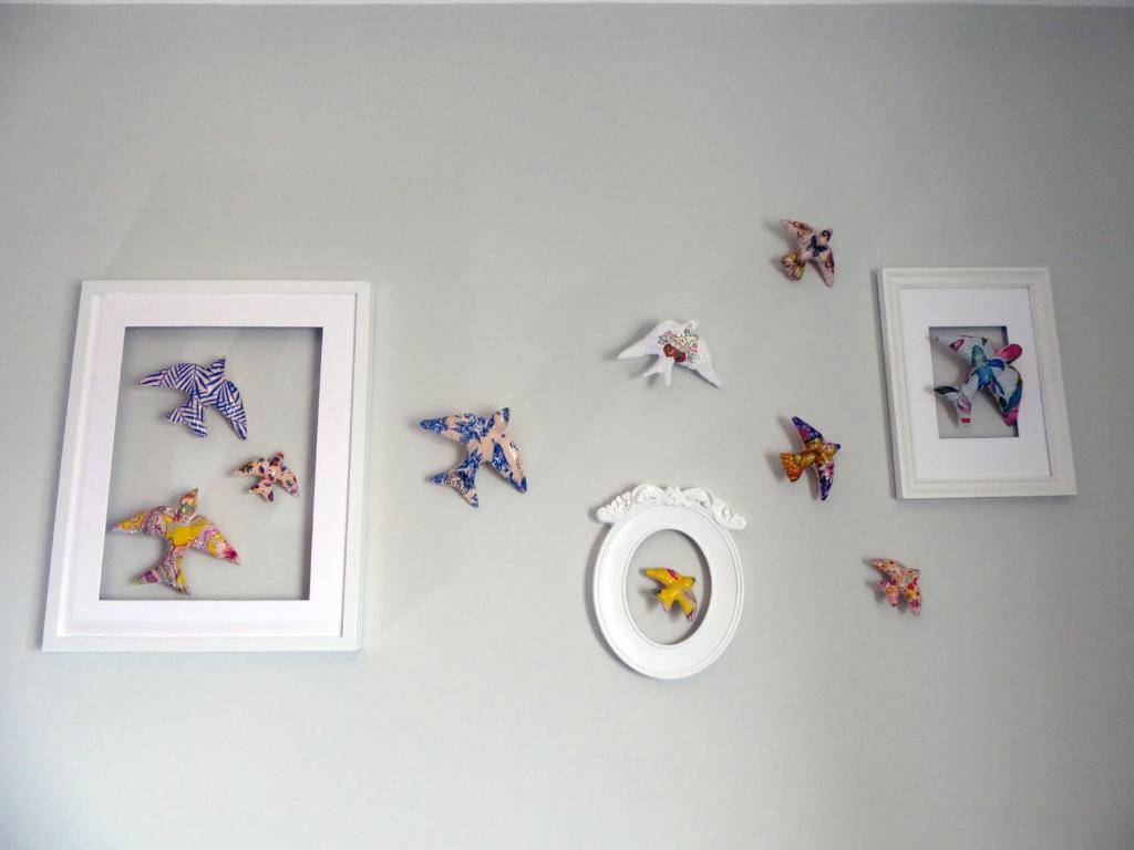 a white wall with framed pictures and a mirror at Near Beach Apartment in Póvoa de Varzim