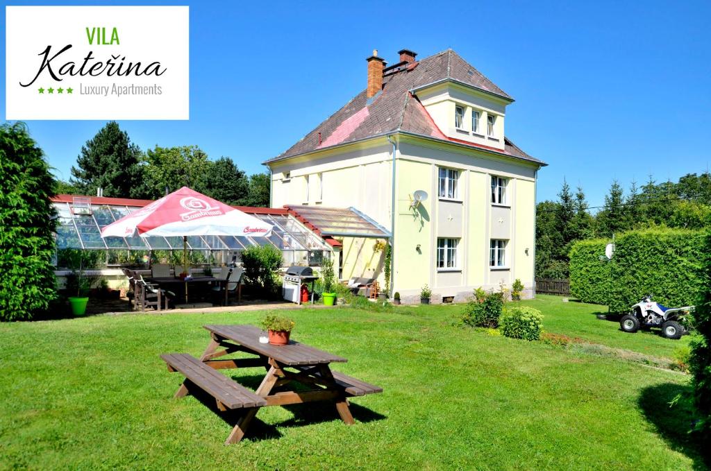 una mesa de picnic en el césped frente a un edificio en Vila Kateřina en Broumov