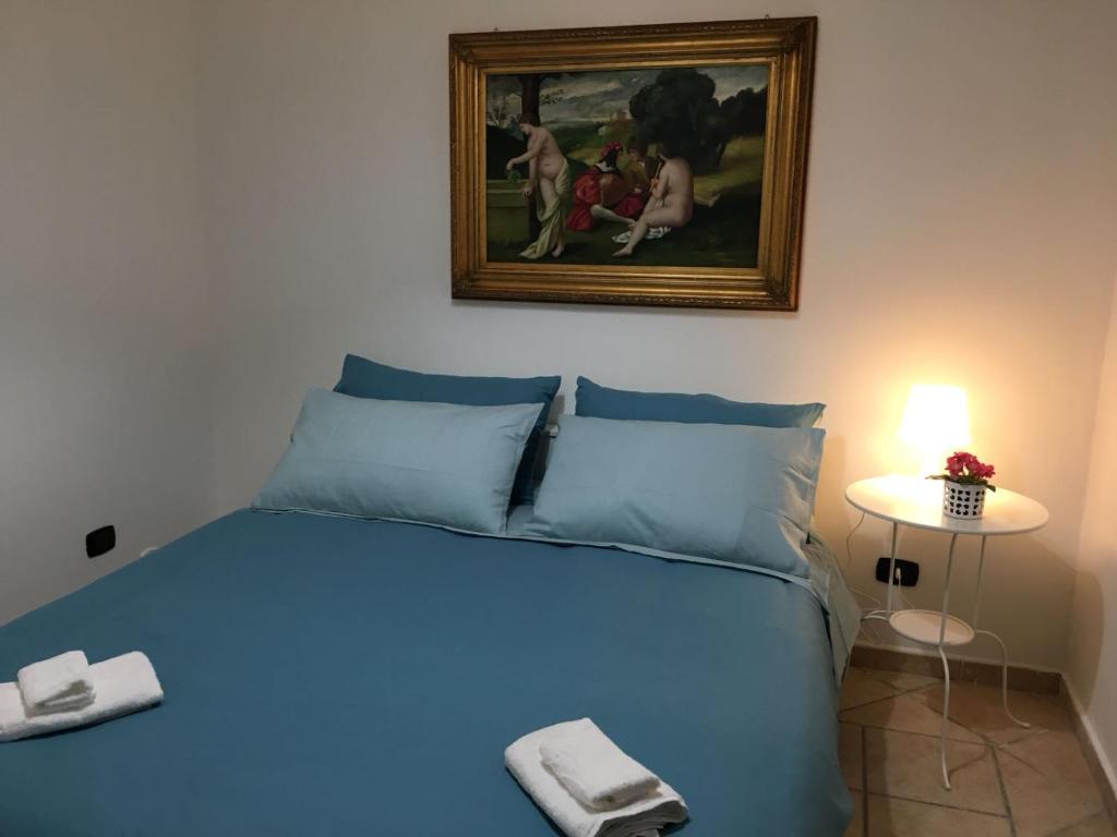 バーリにあるFlores Apartmentのベッドルーム1室(壁に絵画が描かれた青いベッド1台付)