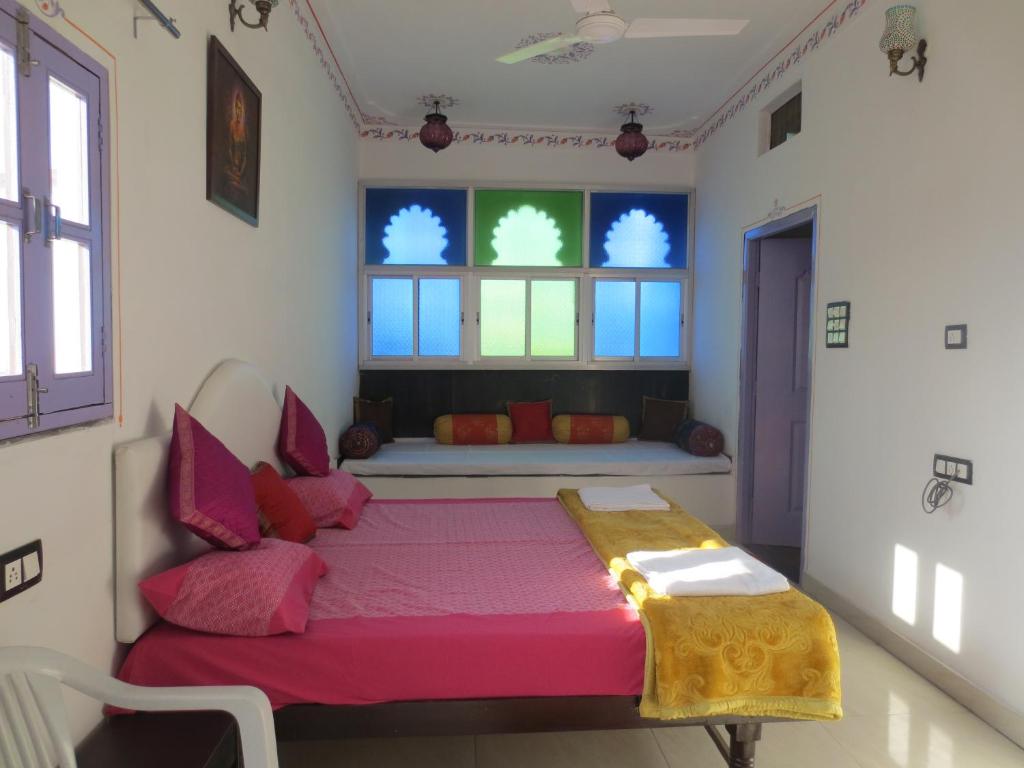 a bedroom with a pink bed and a window at Bansi Niwas in Udaipur