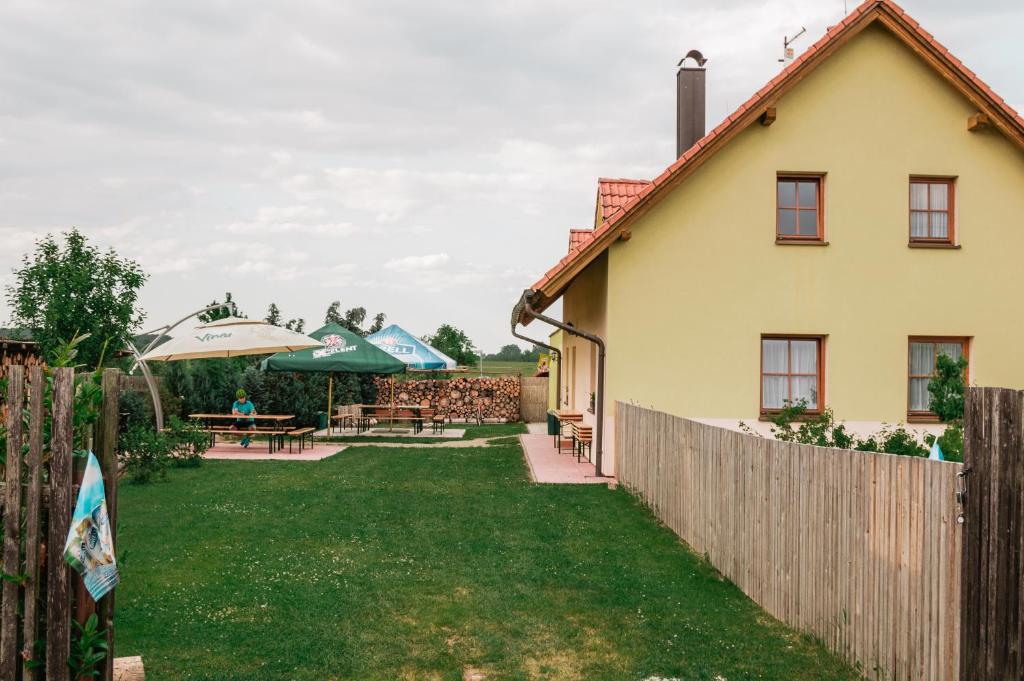 ein Haus mit einem Zaun und einem Hof in der Unterkunft Občerstvení u cyklostezky in Břehov