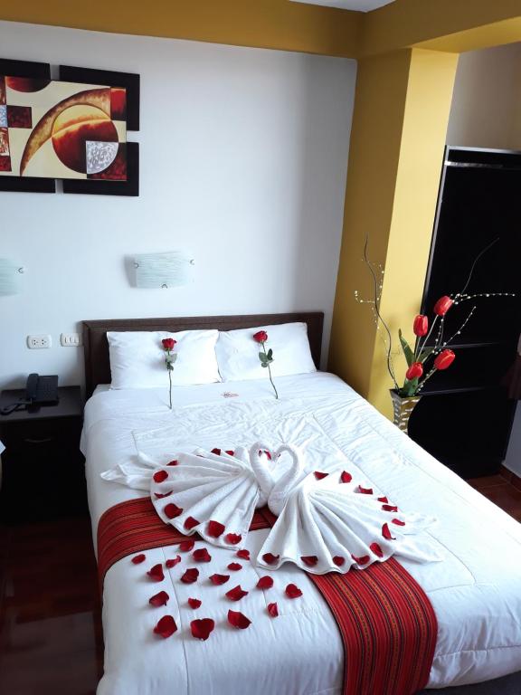 Una cama con un corazón hecho de rosas rojas en Pumas Cusco Hotel, en Cusco