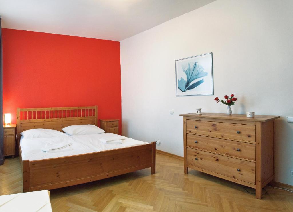 ein Schlafzimmer mit einem Bett und einer Holzkommode in der Unterkunft Ai Quattro Angeli in Prag