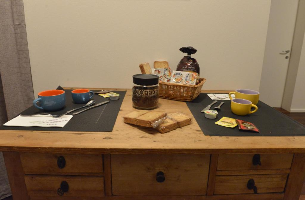 een houten tafel met twee borden en kopjes erop bij Biker's Wine House in Rovereto