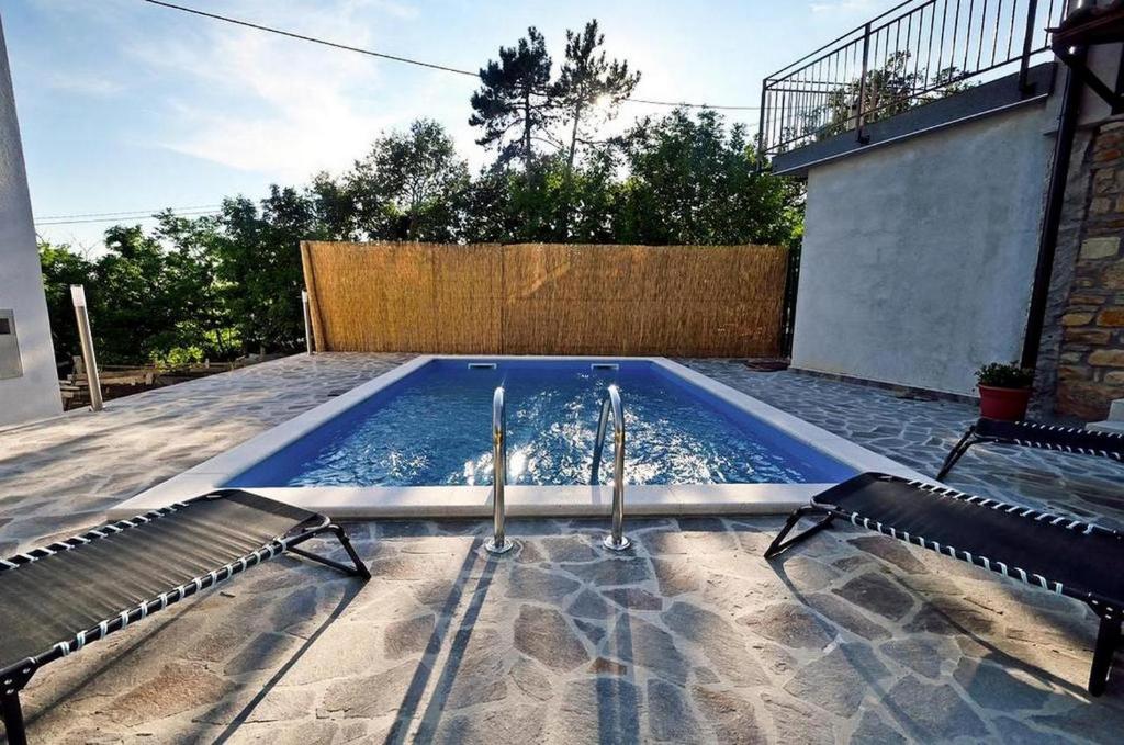 una piscina en un patio con 2 sillas en Holiday House Eda with Private Pool, en Buzet