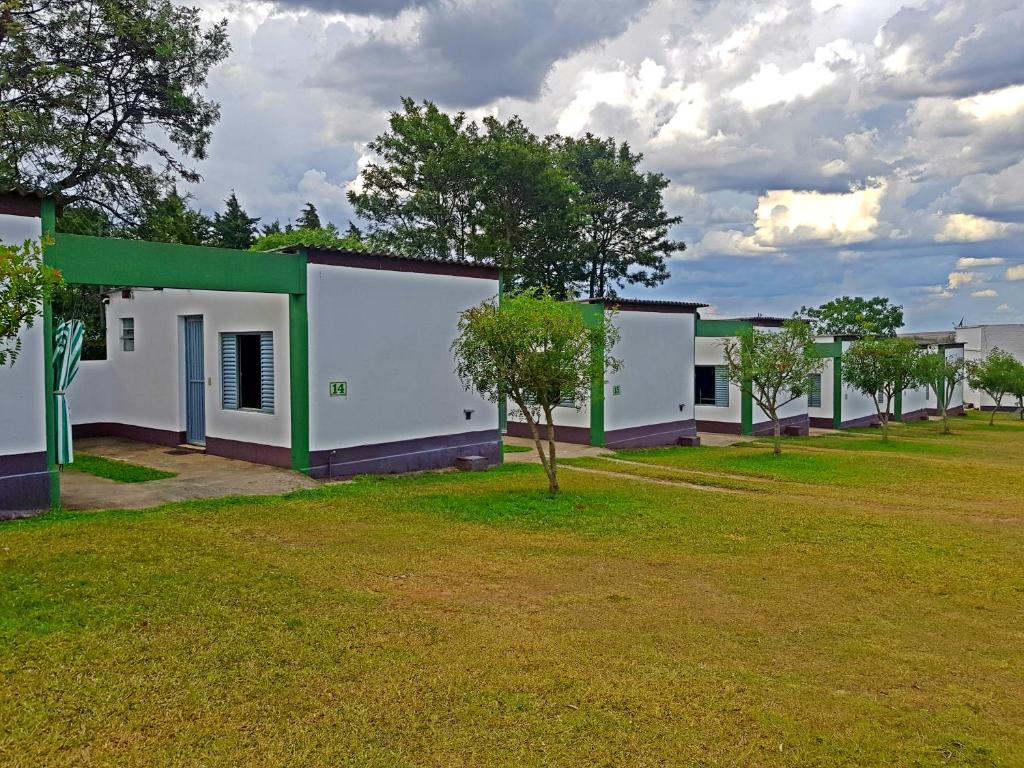 a row of houses with trees in a field at Hotel Comodoro De Quaraí in Quaraí