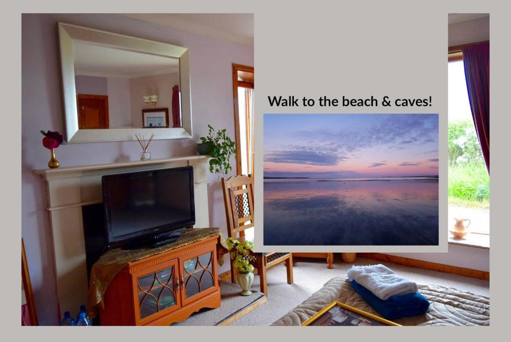 a living room with a tv and a mirror at Room by the Beach in Aird Tong