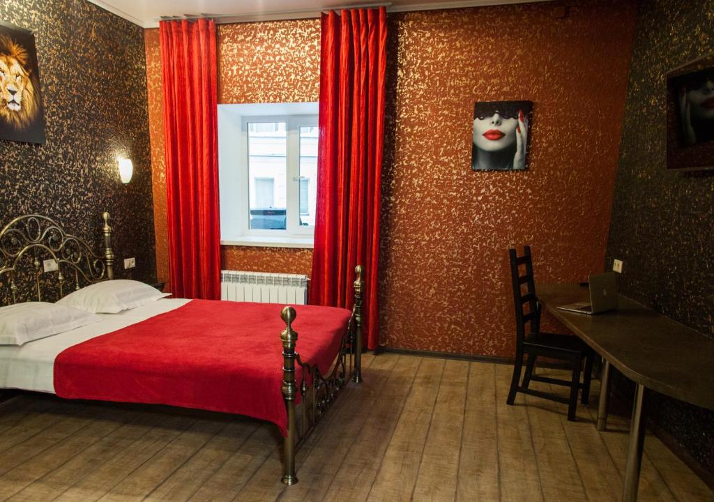 a bedroom with a red bed and a window at Pokrovskiy Dom in Moscow