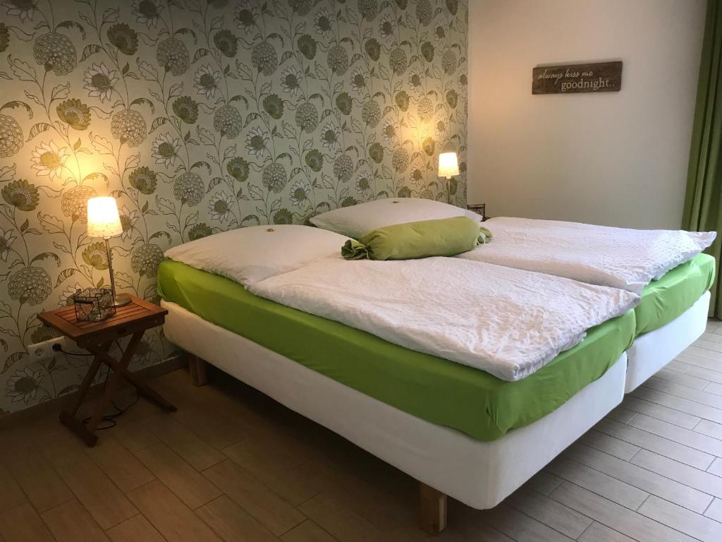 1 dormitorio con 1 cama con sábanas verdes y blancas en SEASIDE APARTMENTS - DREAMY GREEN, en Eckernförde