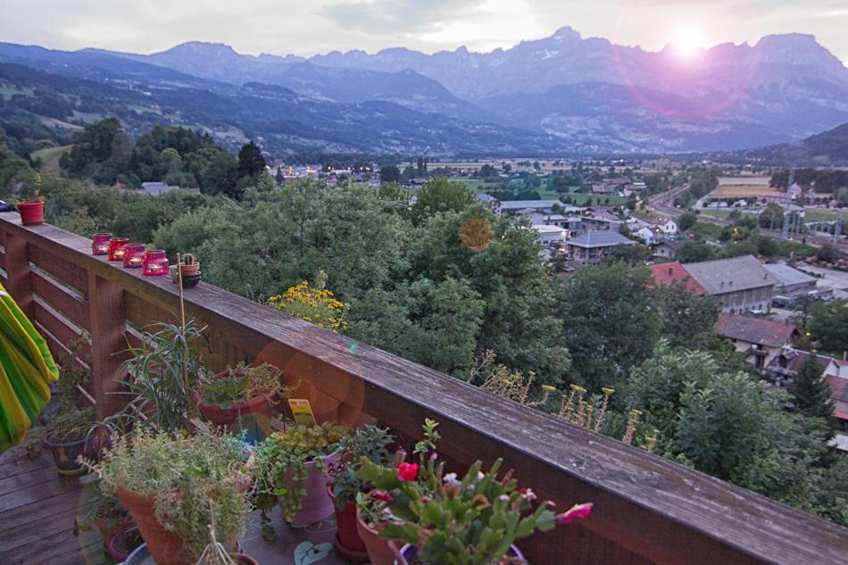 サン・ジェルヴェ・レ・バンにあるLe Mont Fleuri Saint Gervais Les Bainsの鉢植えの植物が植えられたバルコニーから市街の景色を望めます。