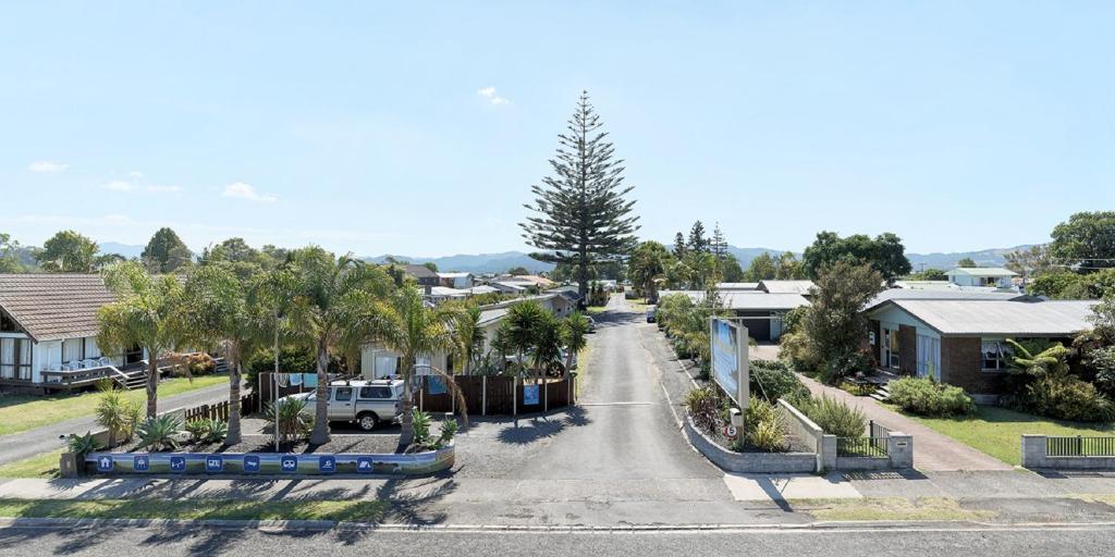 an empty street in a residential neighborhood with houses at Mercury Bay Holiday Park in Whitianga