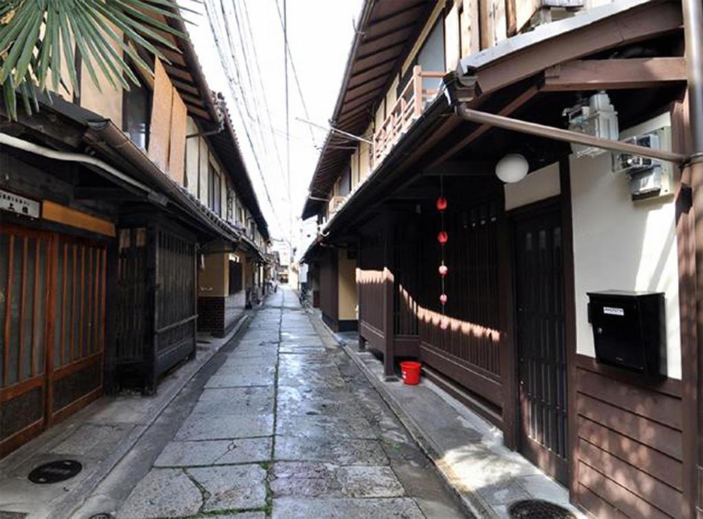 an empty alley way with buildings and a street at Maeniiya Machiya Inn in Kyoto