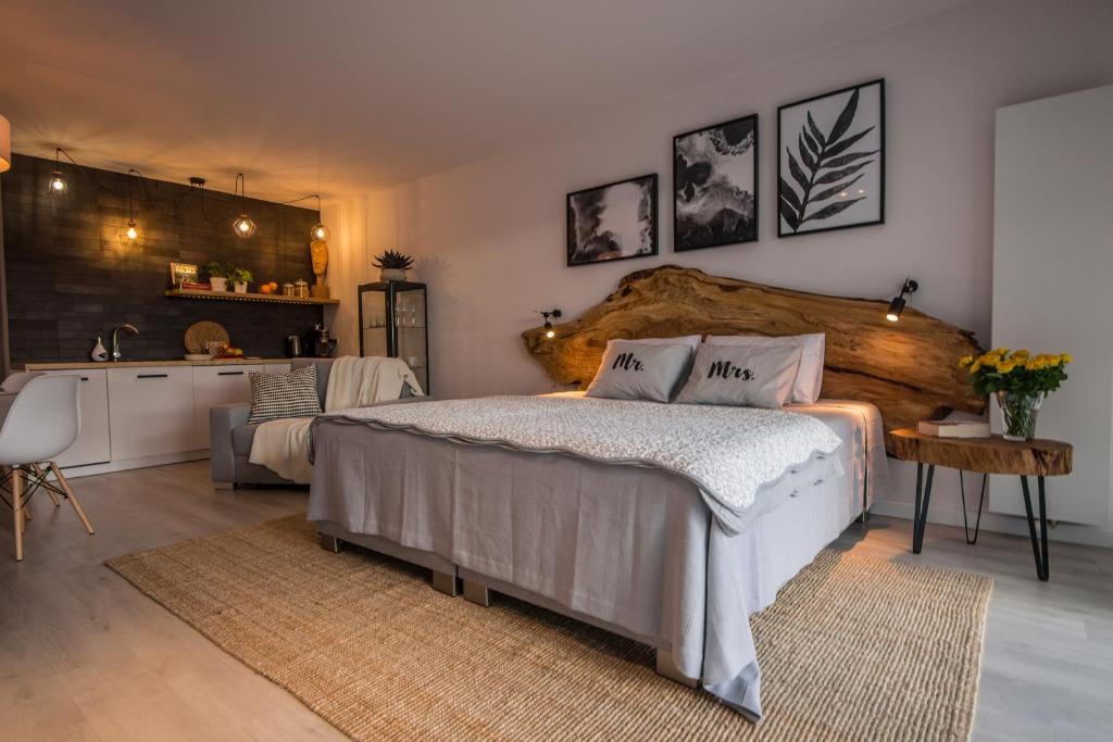 a bedroom with a large bed and a kitchen at ApartWisła in Wisła