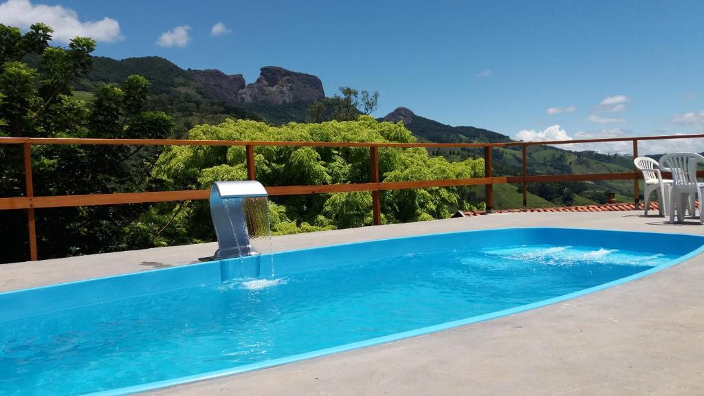 a swimming pool with a water fountain on a balcony at Chales Azaleia in São Bento do Sapucaí