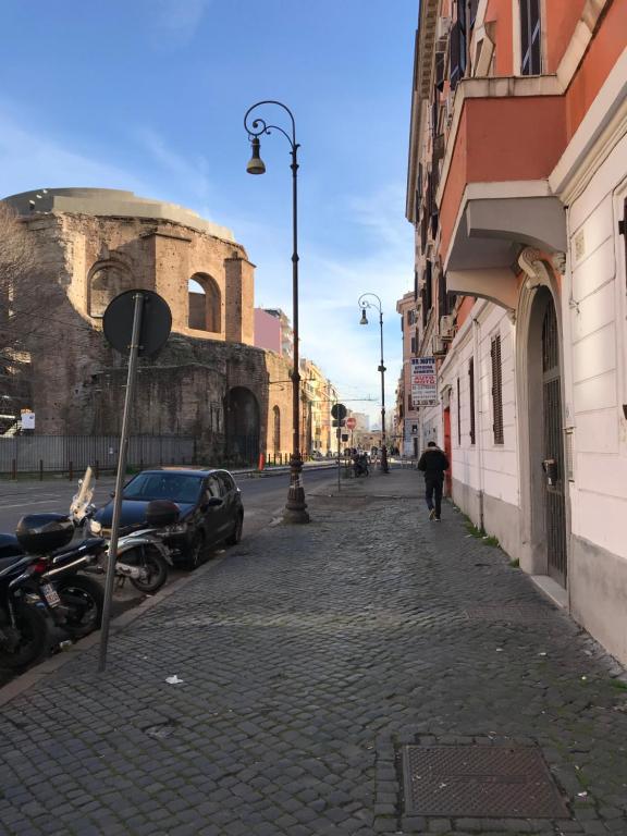 a person walking down a cobblestone street next to a building at Dormire a Roma in Rome