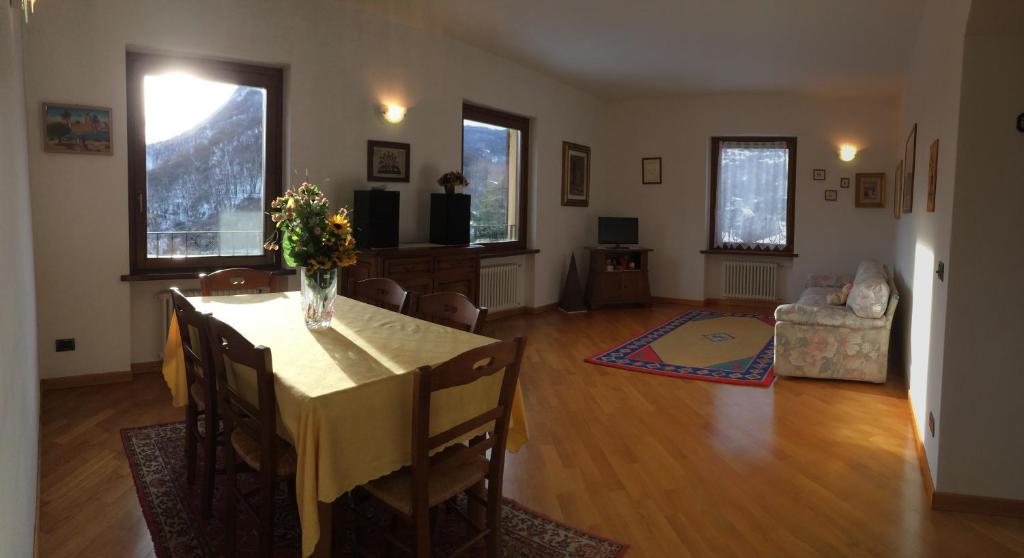 una sala de estar con una mesa con un jarrón de flores. en Appartamento Al Canelino - Como Lake and Mountains en Asso