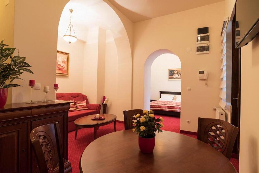 - un salon avec une table et un lit dans l'établissement Apartament Baroc, à Timişoara