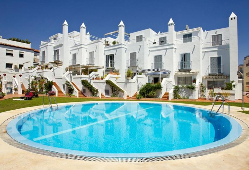 a swimming pool in front of a large white building at Los Huertos de Nerja 6 in Nerja