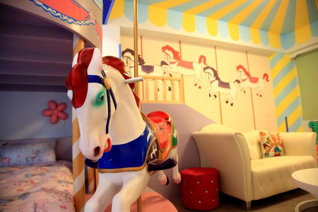 - une chambre pour enfants avec un cheval jouet devant un lit dans l'établissement We Love B&B, à Anping