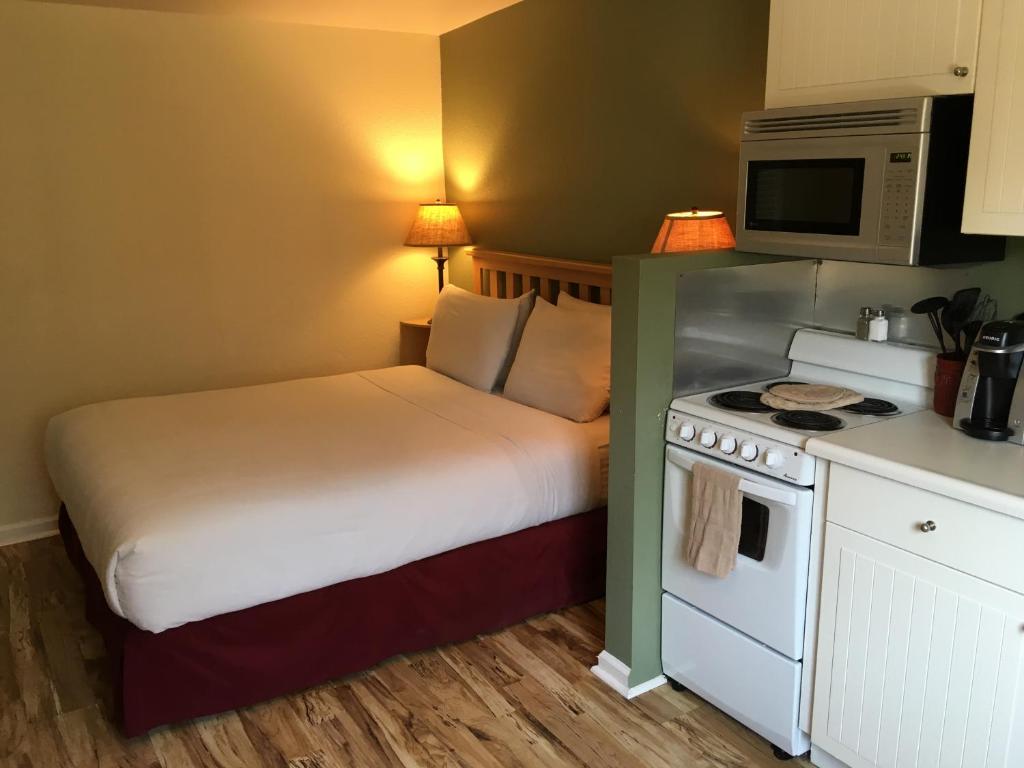 a bedroom with a bed and a microwave and a stove at Clear Lake Cottages & Marina in Clearlake