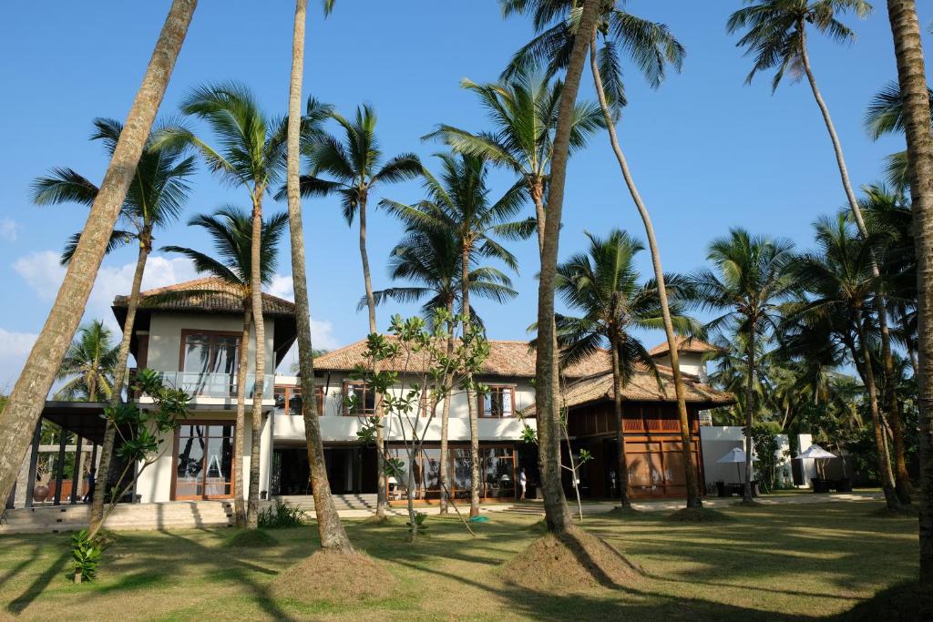 a resort with palm trees in front of it at The Villa by Contemporary Ceylon in Wadduwa