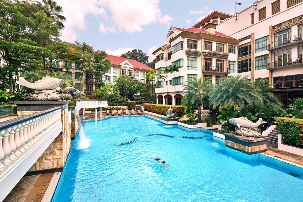 a pool at a resort with people swimming in it at Treetops Executive Residences in Singapore