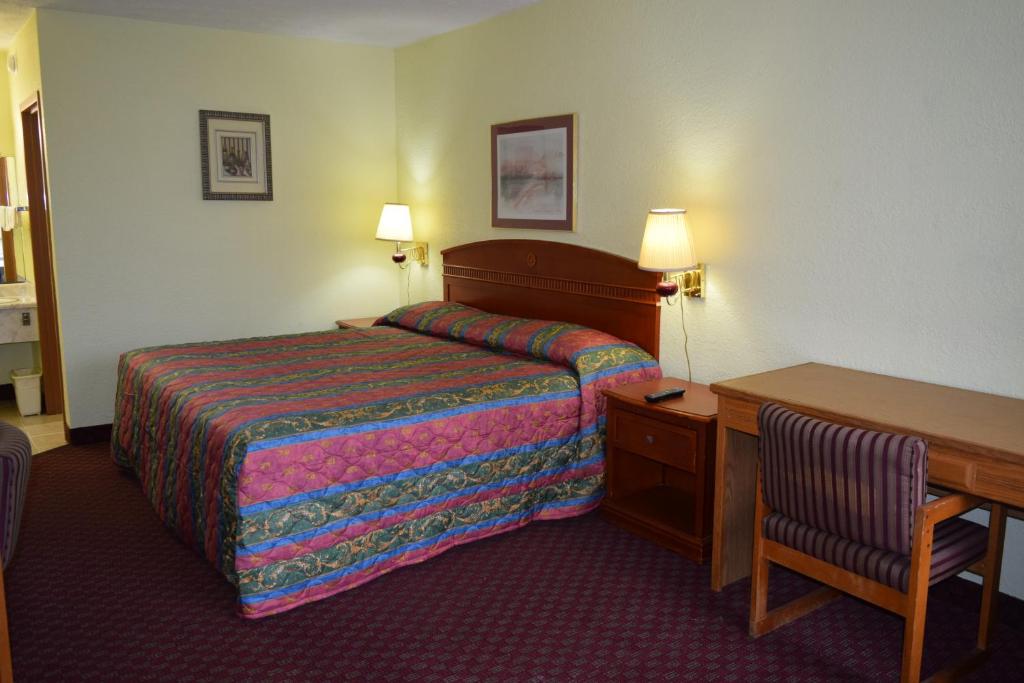 una camera d'albergo con letto e scrivania di Budget Inn Express a Louisa