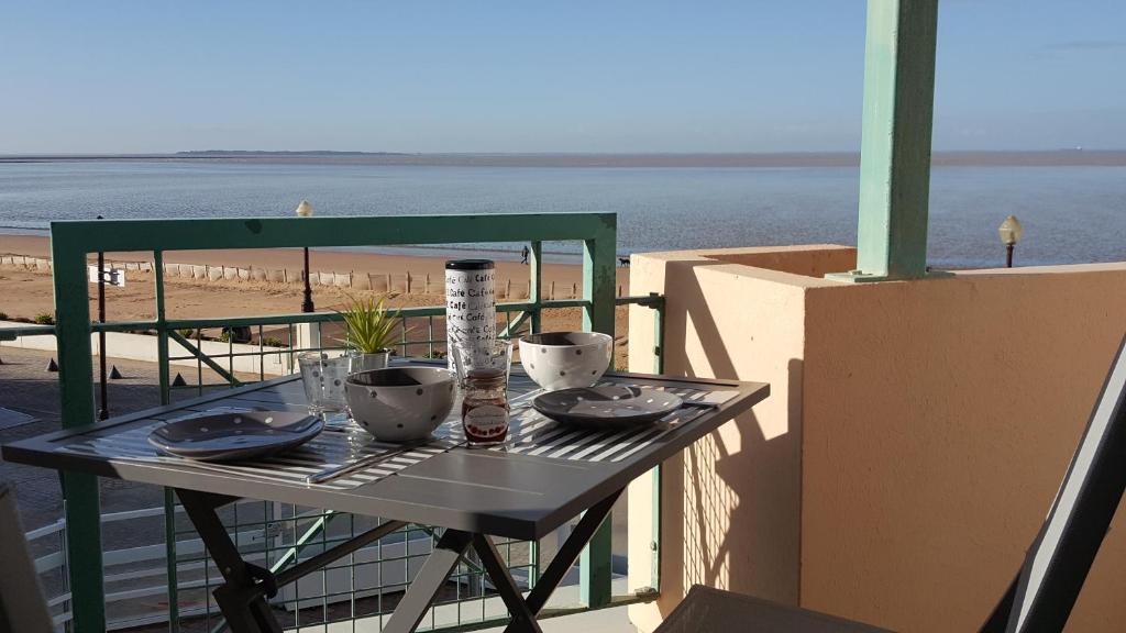 - une table sur un balcon avec vue sur la plage dans l'établissement Résidence TROUVILLE, à Châtelaillon-Plage