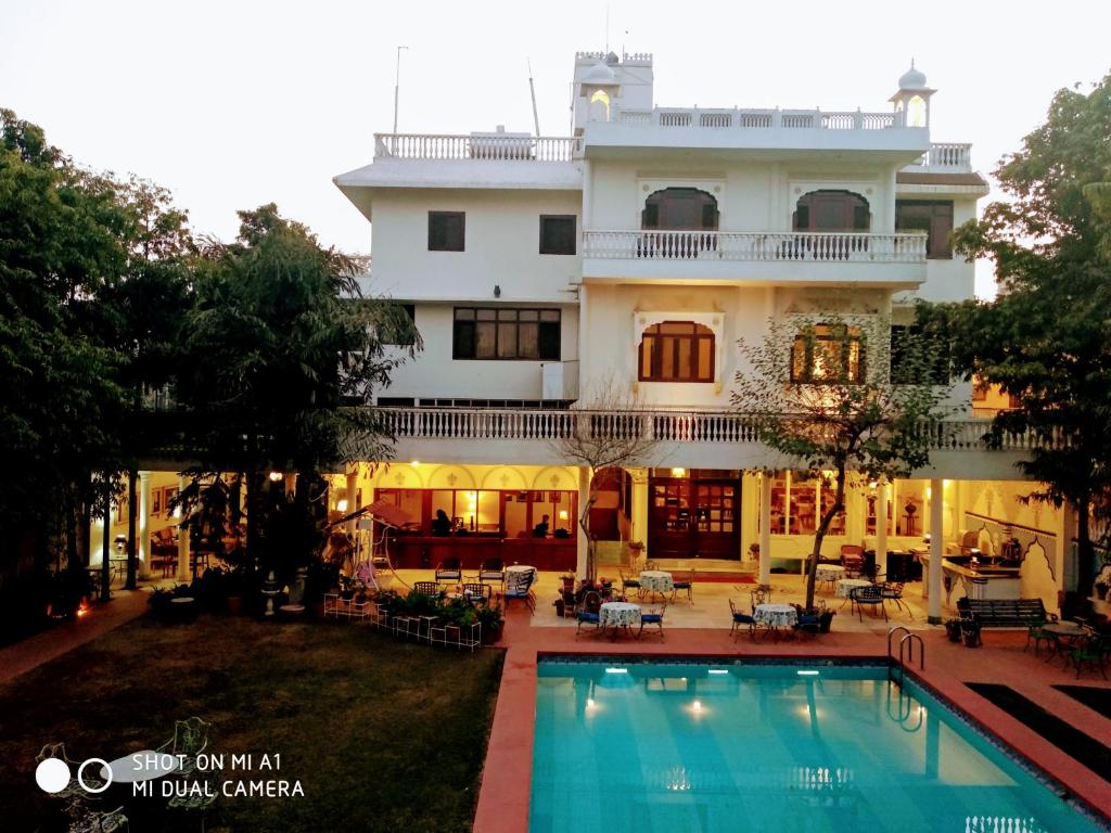 un hotel con piscina di fronte a un edificio di Hotel Meghniwas a Jaipur