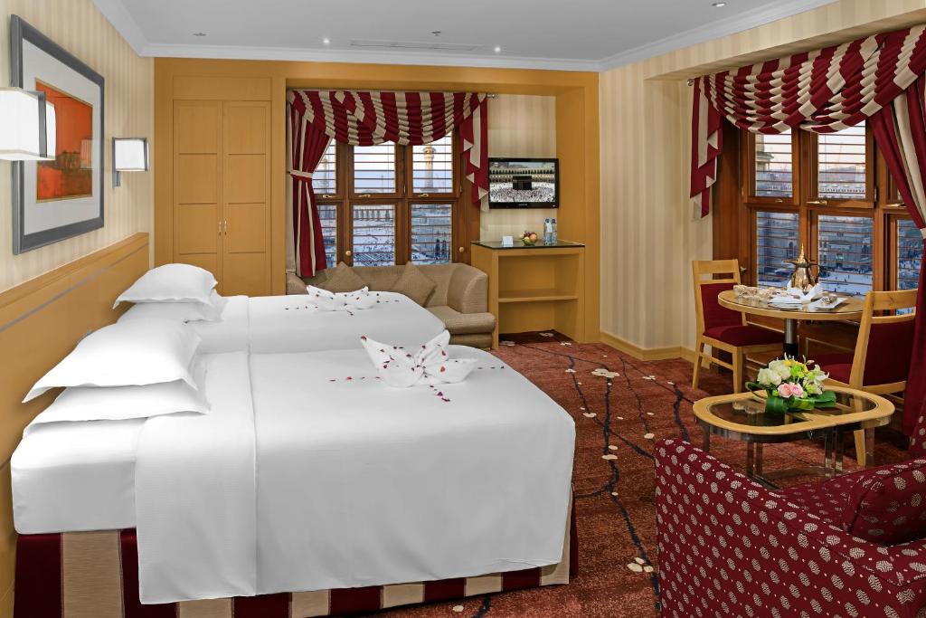 a hotel room with two beds and a table at Makkah Towers in Mecca