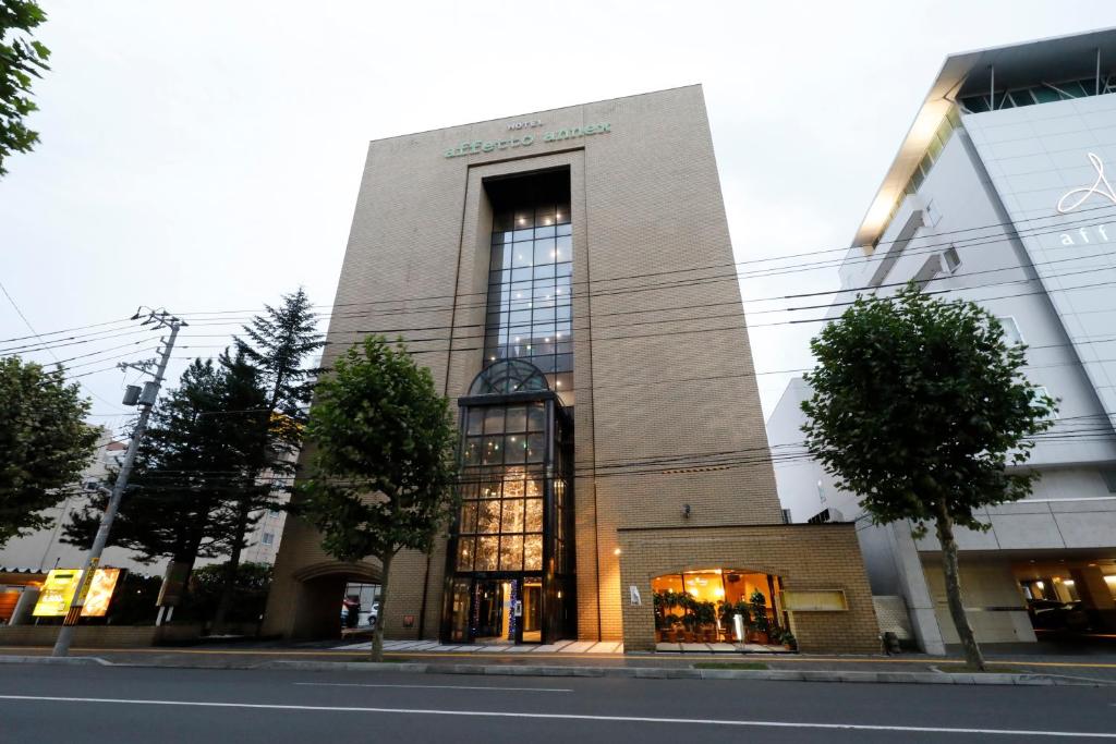 un edificio con una gran ventana en una calle en Hotel Annex, en Sapporo