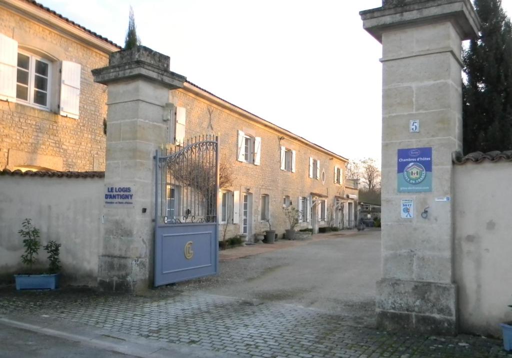 um edifício com um portão ao lado de uma rua em Le Logis d'ANTIGNY em Val-du-Mignon