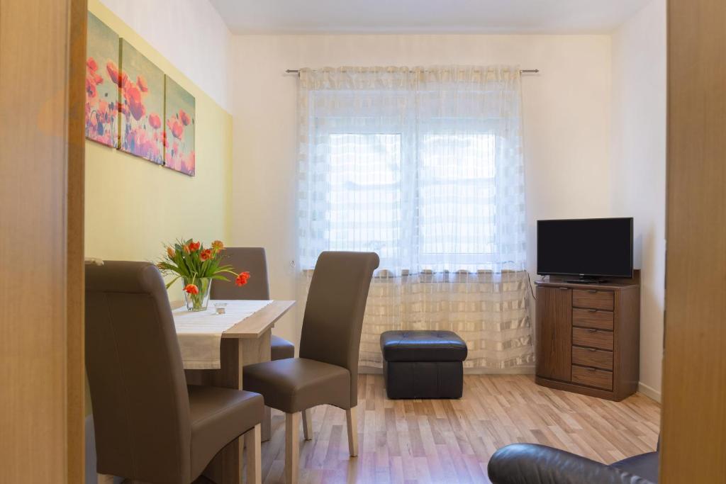 ein Esszimmer mit einem Tisch und einem TV in der Unterkunft Ferienwohnung Wideystrasse in Witten